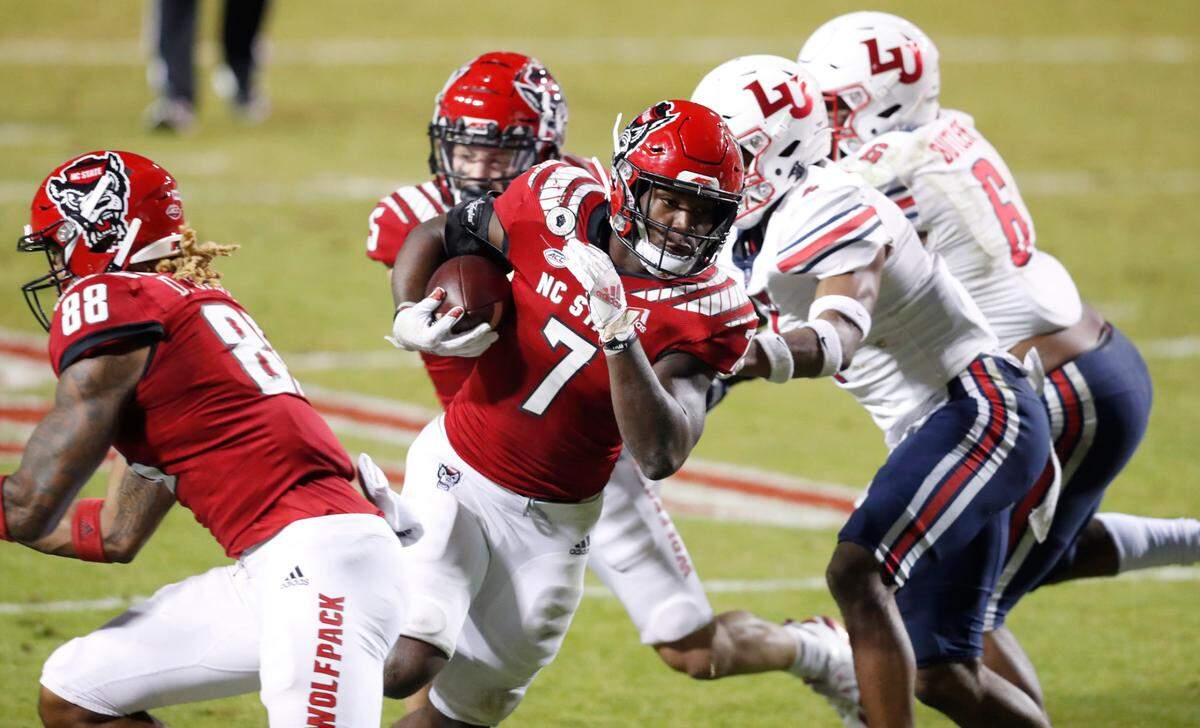 N.C. State running back Zonovan ‘Bam’ Knight (7) avoids Liberty defenders on a 17-yard touchdown run during the first half of N.C. State’s game against Liberty at Carter-Finley Stadium in Raleigh, N.C., Saturday, Nov. 21, 2020.