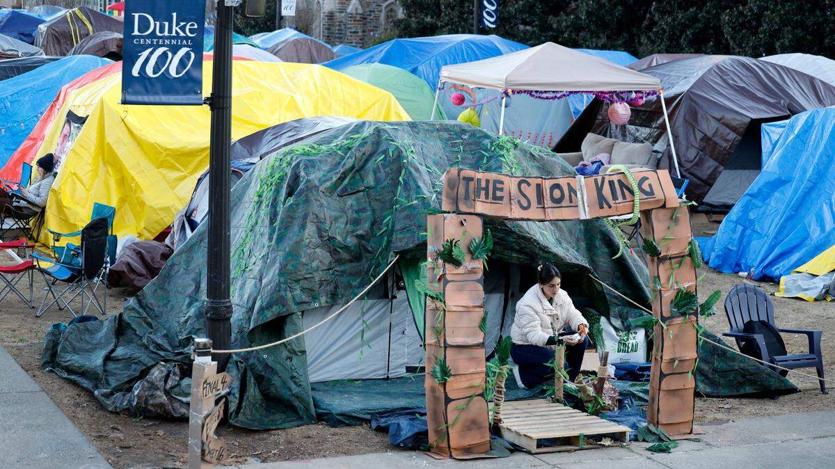 Duke senior Natalia Bojorquez cleans up outside her tent in Krzyzewskiville at Duke University in Durham, N.C., Tuesday, Jan. 28, 2025. The is the 39th year of tenting for students who want to attend the game against UNC. One hundred thirty tents were set up on Jan. 12, with 12 students per tent. It is the only way undergraduates can go to the game.