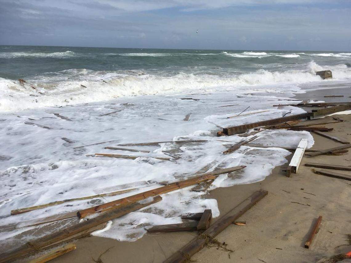 The beach was littered with large pieces of wood, some with nails sticking out of them, as the ocean tore a Rodanthe house apart during Hurricane Chris.