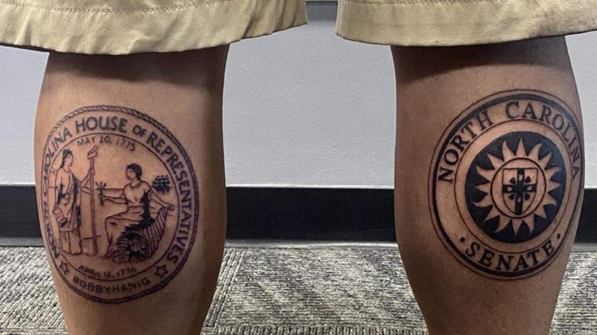 A screenshot of a mysterious lawmaker’s new tattoos on their calves in a tweet from North Carolina lobbyist Brian Lewis’ Twitter.