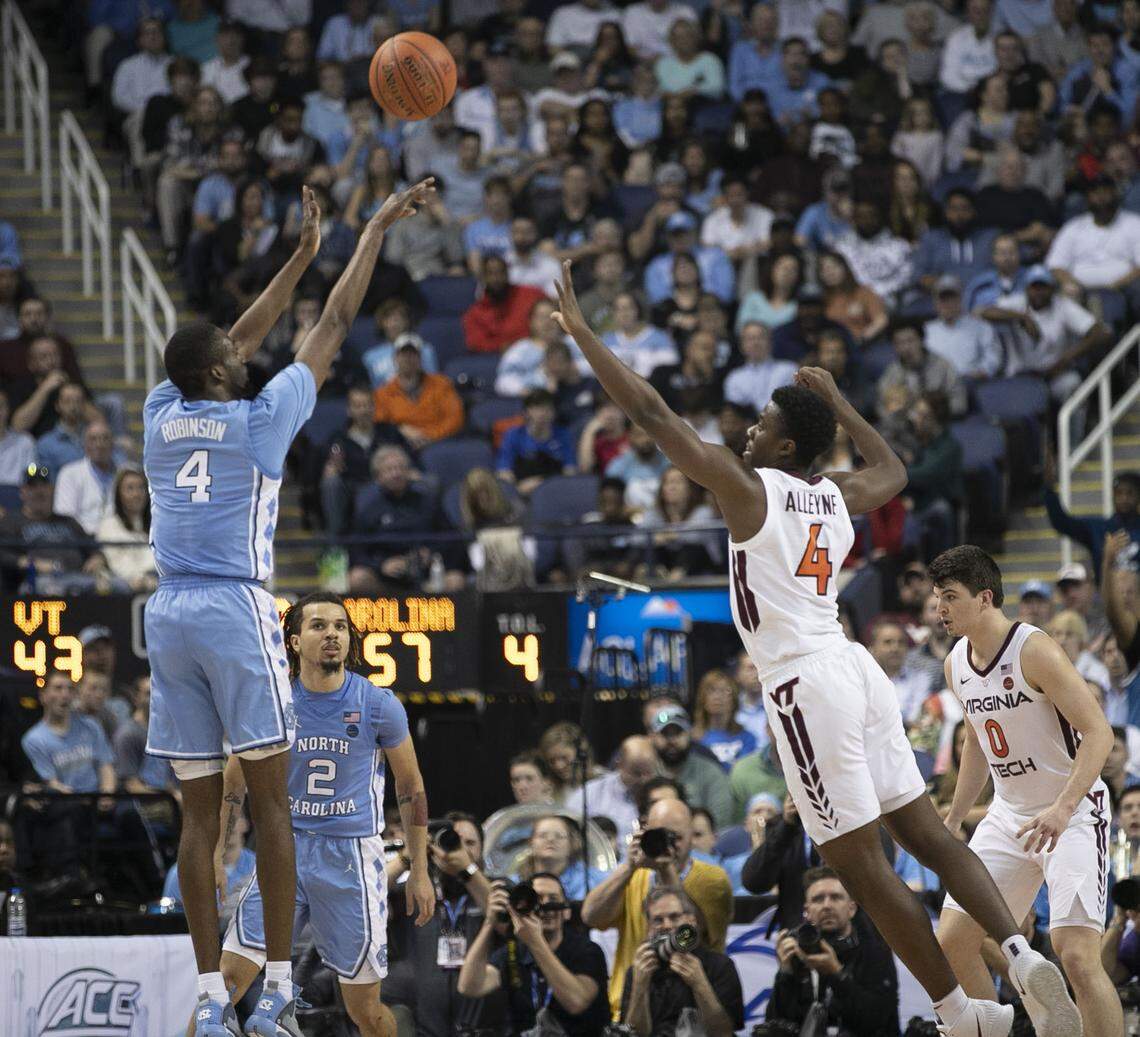 North Carolina’s Brandon Robinson (4) launches a three-point shot over Virginia Tech’s Nahiem Alleyne (4) in the second half on Tuesday, March 10, 2020 during the first round of the ACC Tournament at the Greensboro Coliseum in Greensboro, N.C. Robinson scored 17 points, shooting 5 of 6 from the three point line.