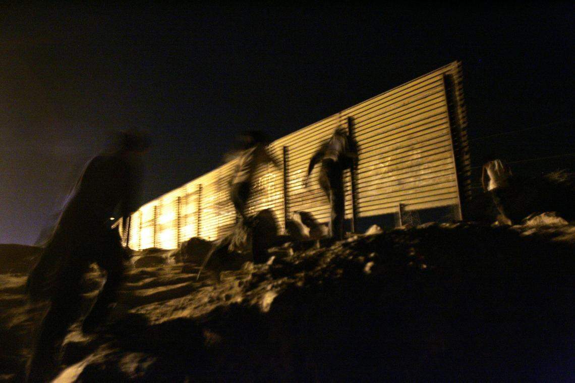 With North Carolina National Guard soldiers about a mile away, and the Border Patrol much closer, Mexicans who had started to cross illegally into the United States turn back toward San Luis Rio Colorado, Mexico, following their smuggler (in front, at border fence). The smuggler, who made the decision not to push forward, said, “there are too many watching tonight.” The fence ends at the Colorado River which acts as a barrier along the United States-Mexico border.