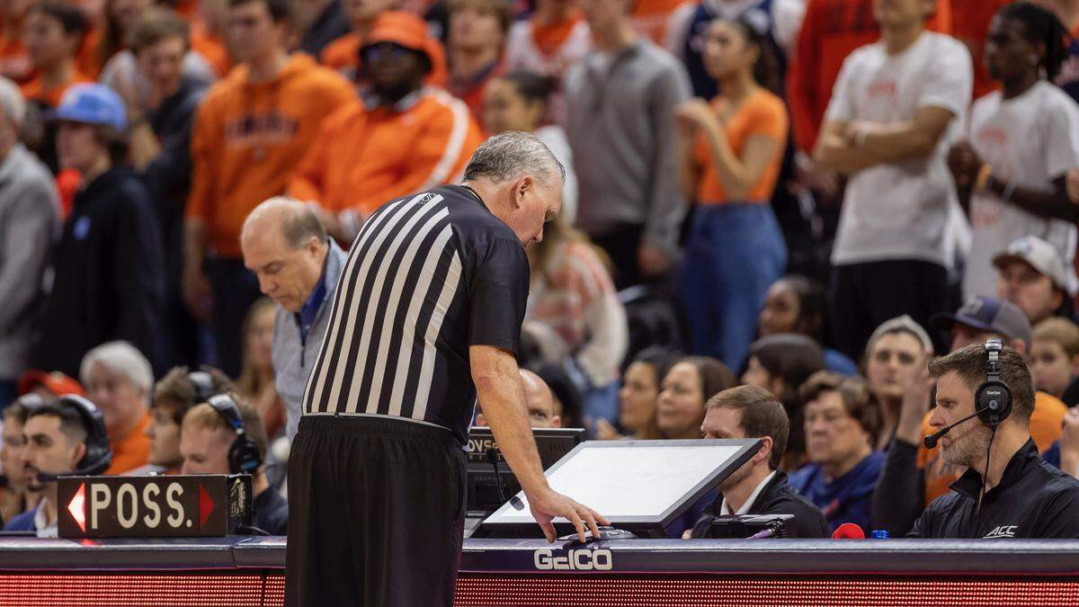 An official reviews a play on a video monitor during UNC’s game at Virginia.  