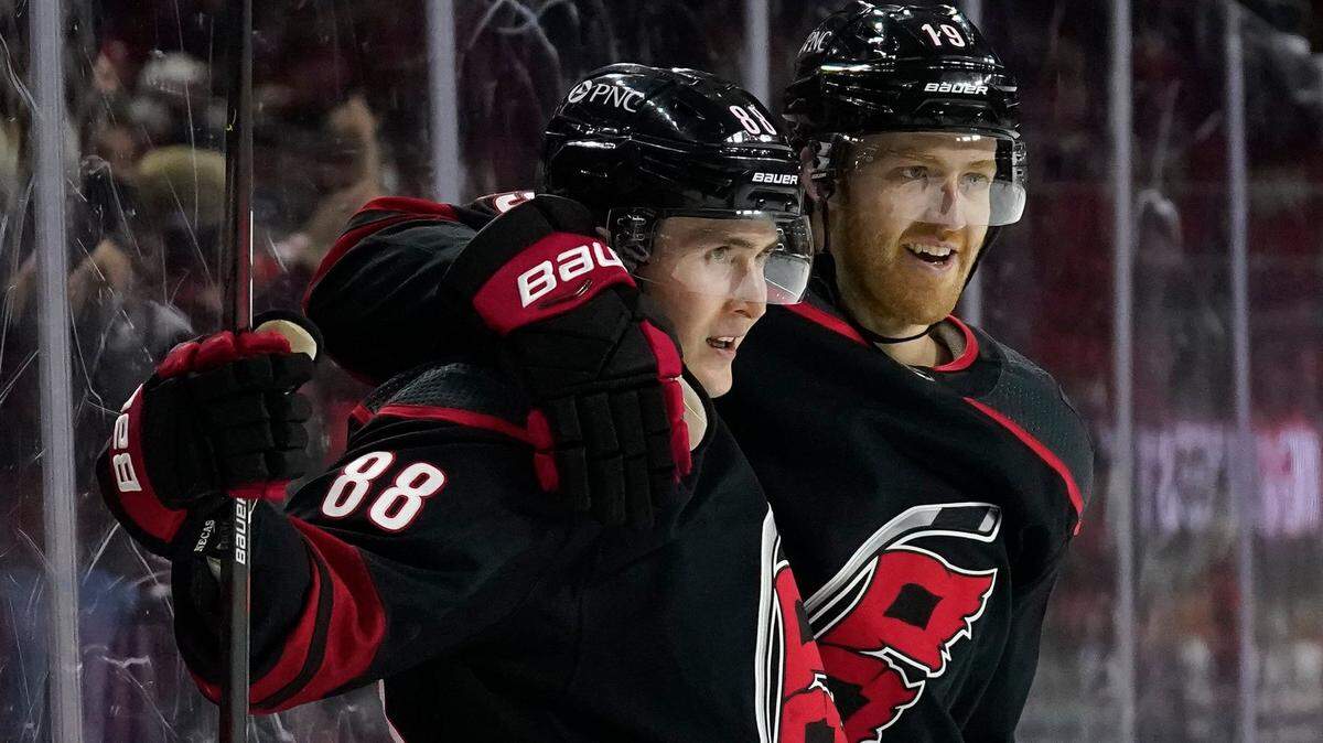 Carolina Hurricanes center Martin Necas (88), of the Czech Republic, and defenseman Dougie Hamilton (19) celebrate Necas’ goal against the Tampa Bay Lightning during the second period of an NHL hockey game in Raleigh, N.C., Saturday, March 27, 2021. (AP Photo/Gerry Broome)