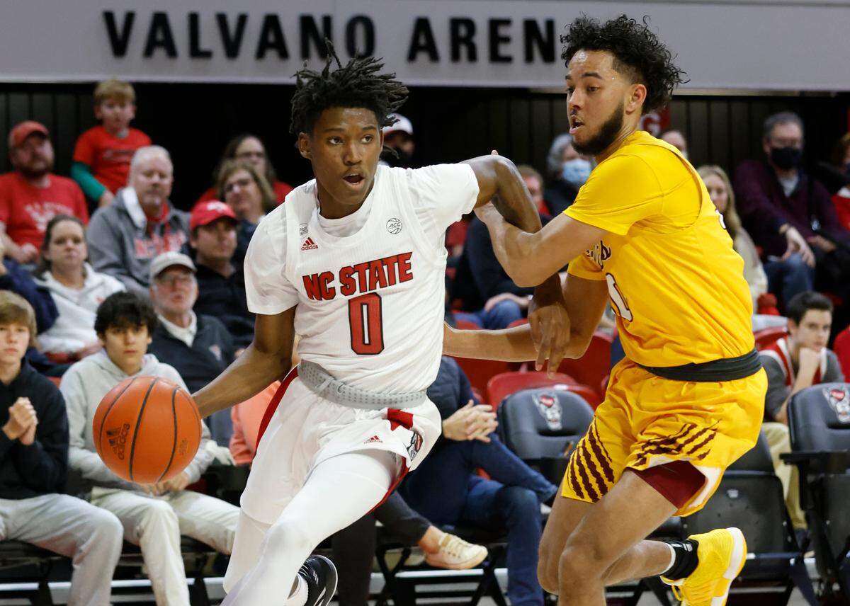 N.C. State’s Terquavion Smith (0) drives by Bethune-Cookman’s Joe French (30) during the first half of N.C. State’s game against Bethune-Cookman University at Reynolds Coliseum in Raleigh, N.C., Thursday, December 9, 2021.