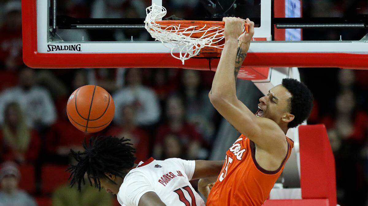Virginia Tech’s Lynn Kidd dunks over N.C. State’s Dennis Parker Jr. during the second half of the Wolfpack’s 84-78 loss on Saturday, Jan. 20, 2024, at PNC Arena in Raleigh, N.C.