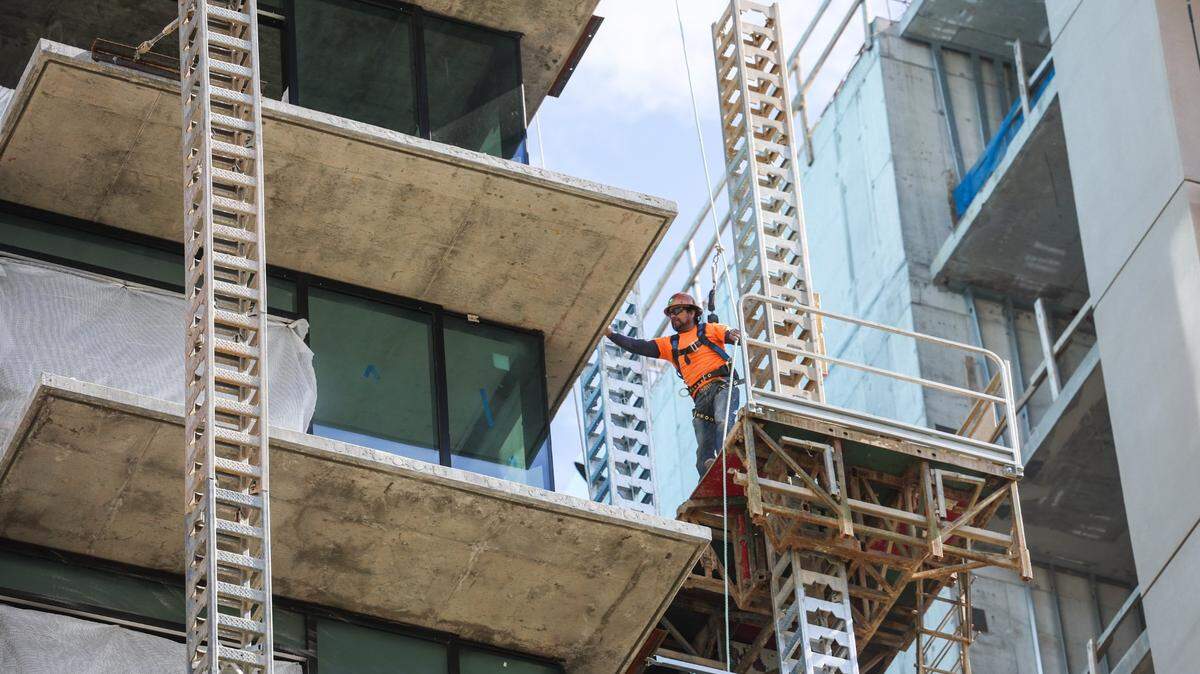 A construction worker stands on scaffolding high above the ground at the site of a 16-story apartment complex in Uptown Charlotte where three workers died in a scaffolding collapse on Jan. 2, 2023.