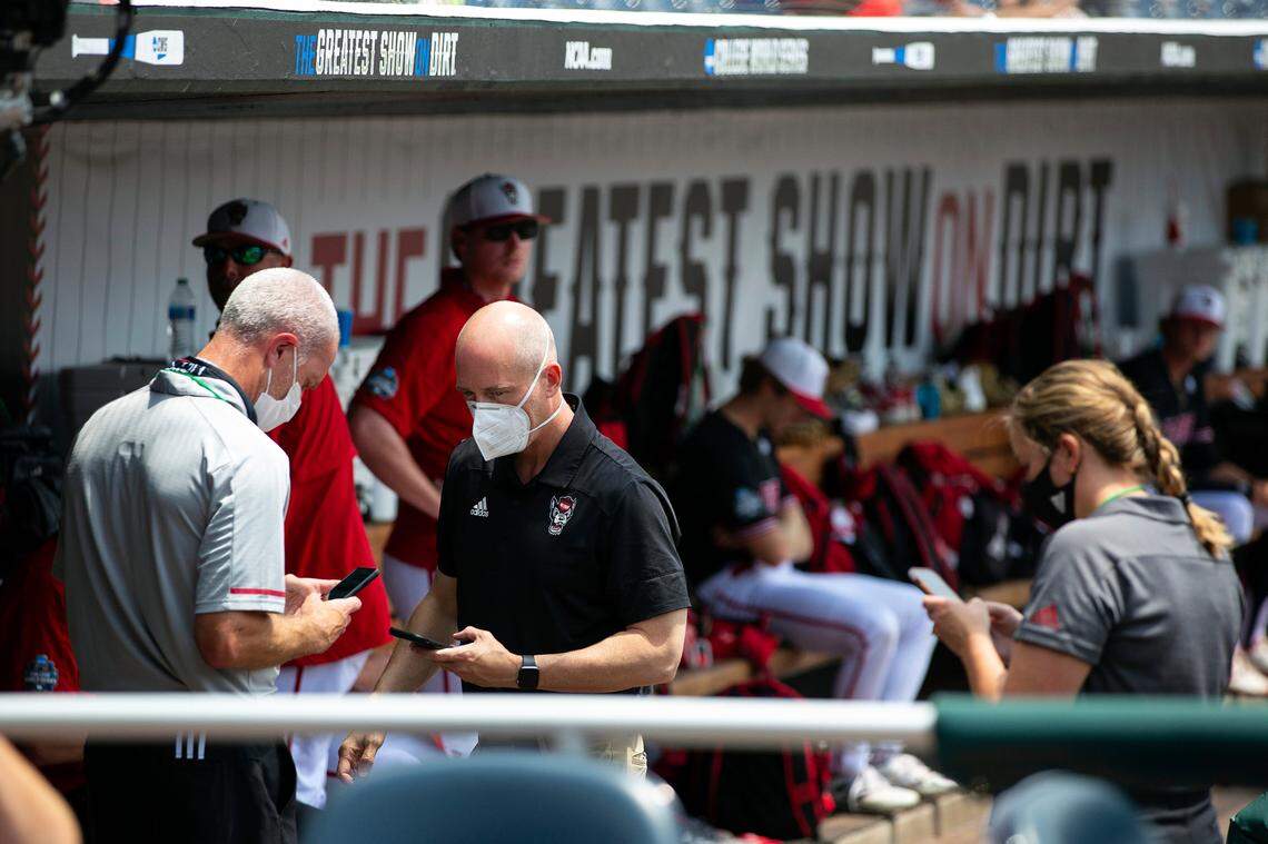 North Carolina State personnel chat in the dugout during a delay due to COVID-19 safety protocols before their baseball game against Vanderbilt in the College World Series Friday, June 25, 2021, at TD Ameritrade Park in Omaha.