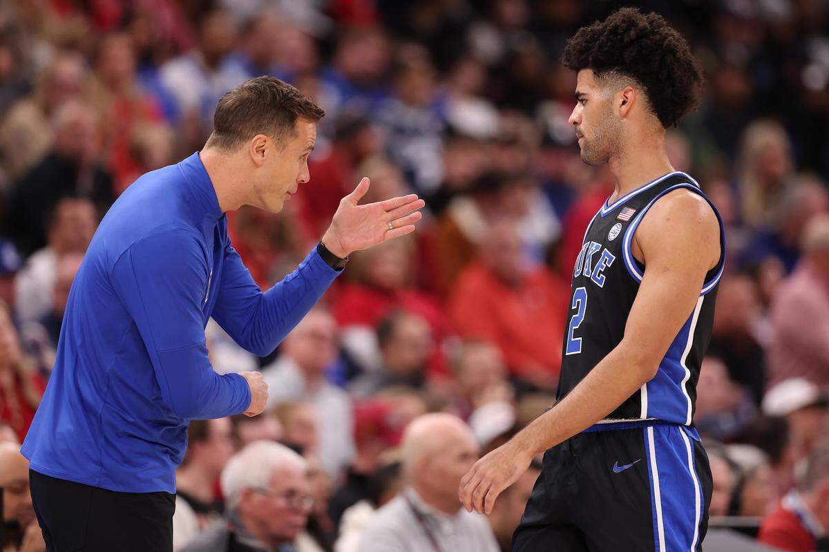 Duke coach Jon Scheyer  talks with Cayden Boozer during action against the Arkansas Razorbacks during the first half of the CBS Thanksgiving Classic at the United Center on November 27, 2025 in Chicago.