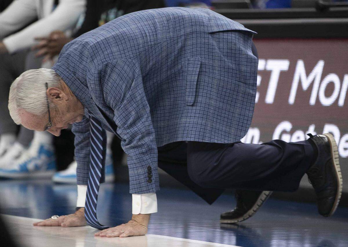 North Carolina coach Roy Williams goes down on his hands and knees as he reacts to poor play by his team in the second half against UCLA on Saturday, December 21, 2019 during the CBS Sports Classic at T-Mobile Arena in Las Vegas, Nevada.