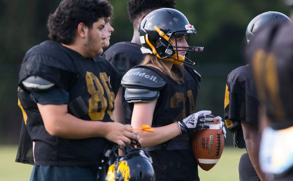 Chapel Hill High School varsity football player Brooklyn Harker, middle, stands with her teammates during practice in Chapel Hill, N.C. on Tuesday, Sept. 14, 2021.