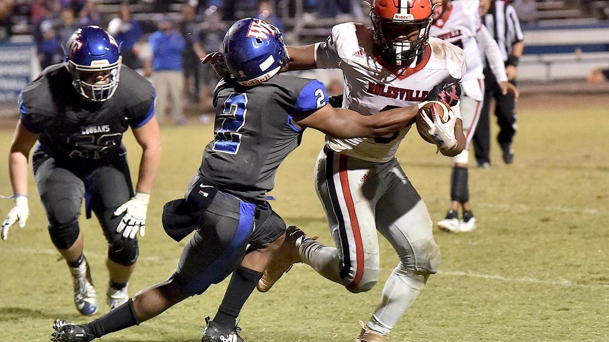 Wake Forest’s Hezekiah Foster (2) grapples Rolesville’s Josh Pullen (6) late in the fourth quarter. The Rolesville Rams and the Wake Forest Cougars met in a regular season football game in Wake Forest, N.C. on October 25, 2019.