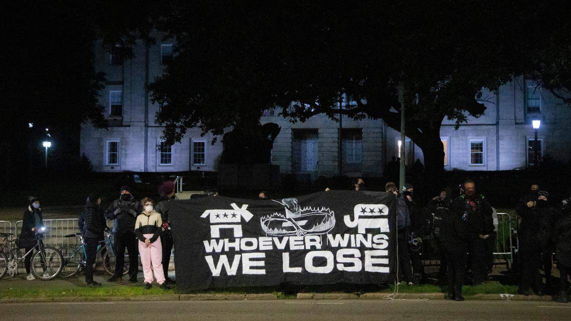 Demonstrators hold a banner before about a hundred protesters marched around downtown Raleigh after polls closed Tuesday, Nov. 3, 2020. Raleigh police made about a half dozen arrests.