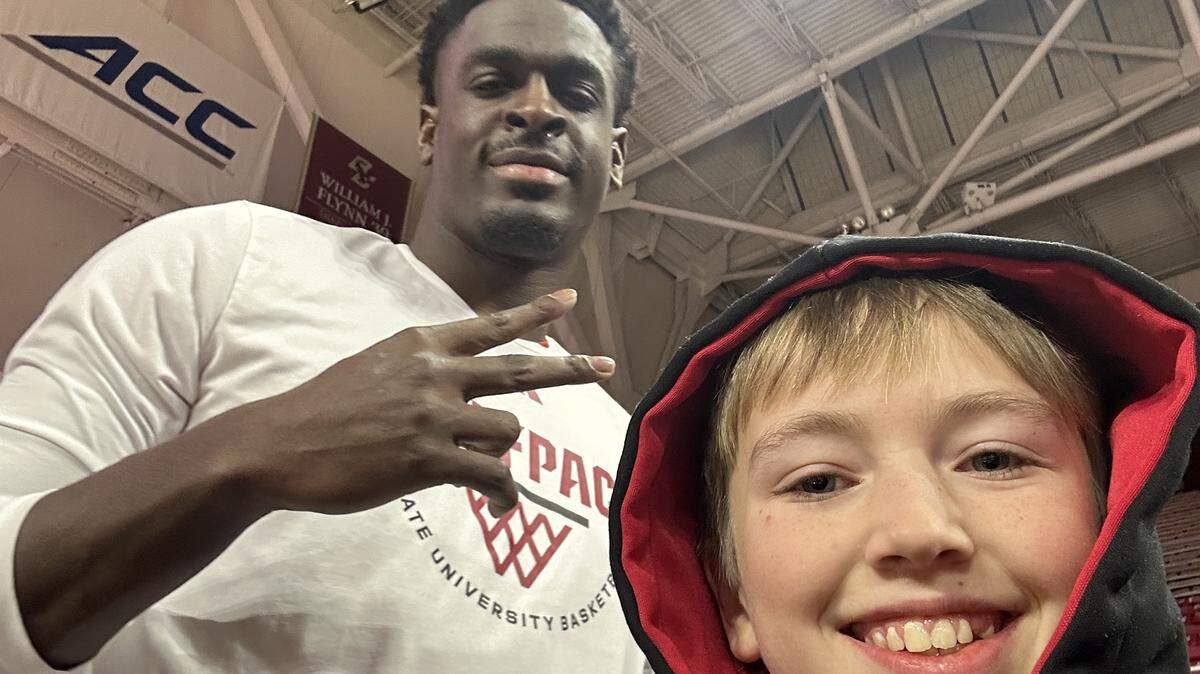 N.C. State’s Scottie Ebube takes a selfie with Finley Hall ahead of the Wolfpack’s men’s basketball game at Boston College on Jan. 6, 2026, in Chestnut Hill, Mass.