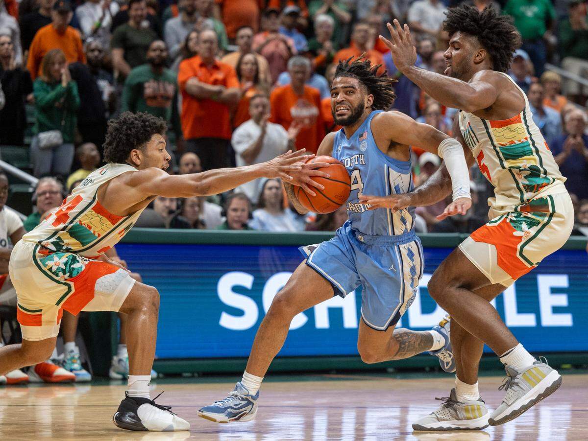 North Carolina’s R.J. Davis (4) drives to the basket between Miami’s Nijel Pack (24) and Norchad Omier (15) in the second half on Saturday, February 10, 2024 at the Watsco Center in Coral Gables, Florid