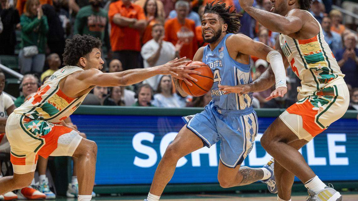 North Carolina’s R.J. Davis (4) drives to the basket between Miami’s Nijel Pack (24) and Norchad Omier (15) in the second half on Saturday, February 10, 2024 at the Watsco Center in Coral Gables, Florid