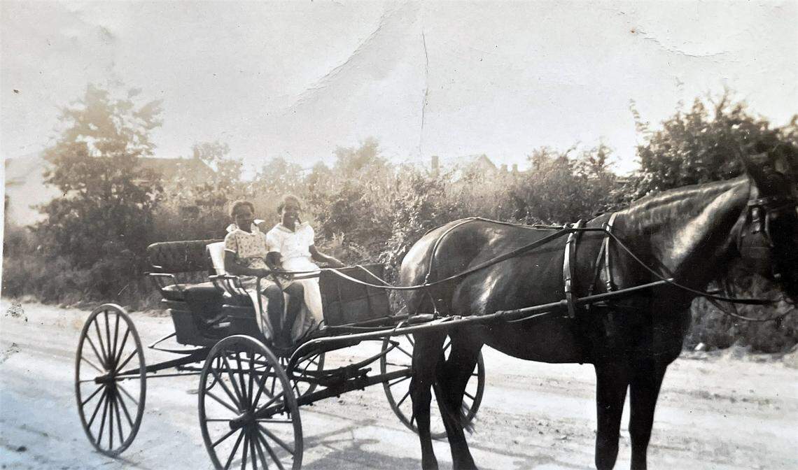 Cousins Dolores Clark and Georgia Bradsher are seen riding in a horse-drawn carriage in Carrboro, N.C. in this family photograph.