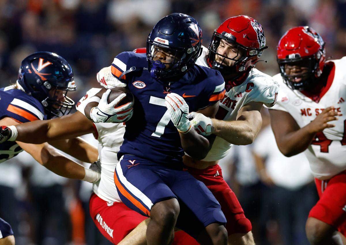 N.C. State linebacker Payton Wilson (11) stops Virginia running back Mike Hollins (7) on third down during the first half of N.C. State’s game against Virginia at Scott Stadium in Charlottesville, Va., Friday, Sept. 22, 2023.