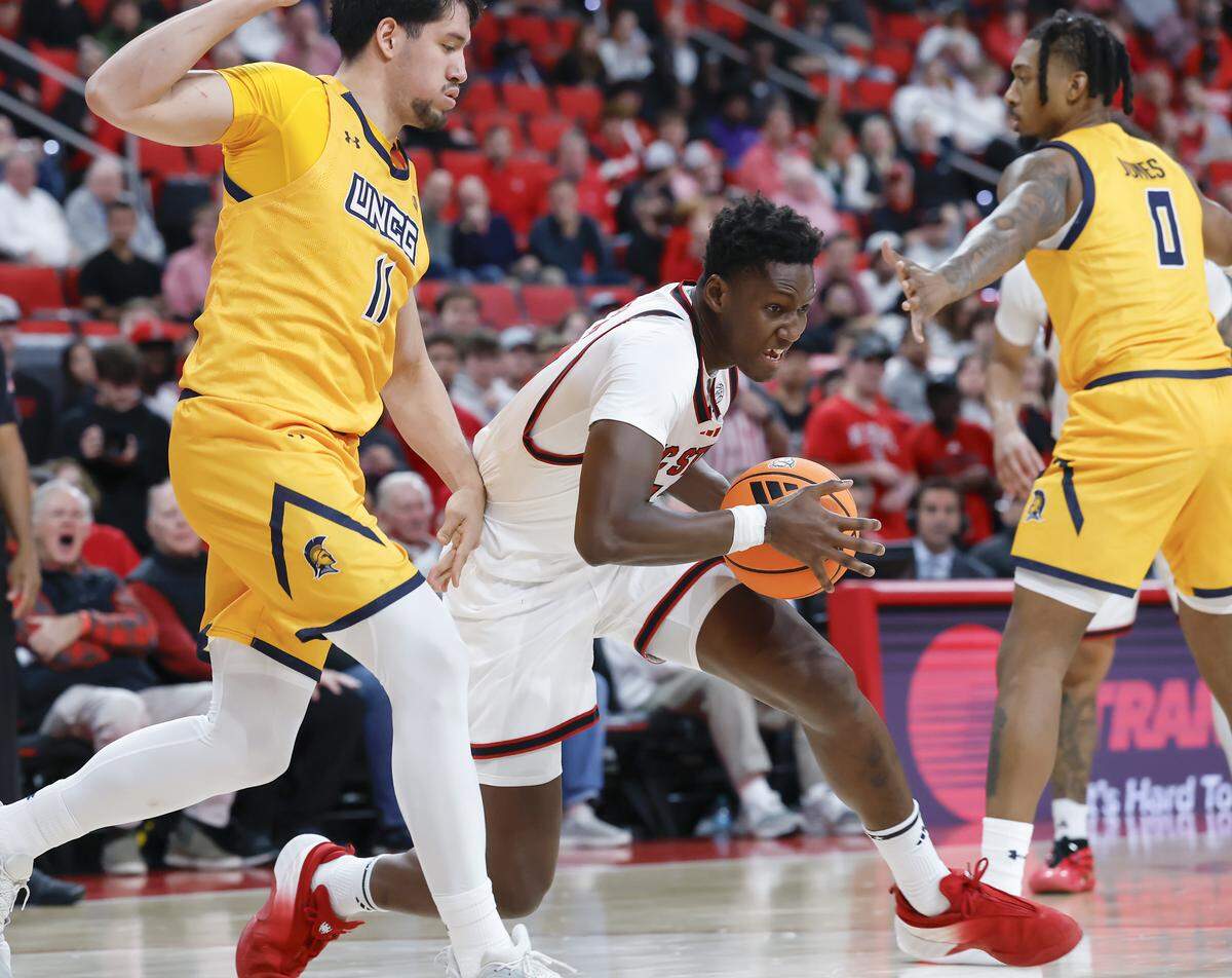 N.C. State’s Musa Sagnia drives around UNC Greensboro’s Valentino Pinedo and Antwann Jones during the second half of the Wolfpack’s 110-64 win on Wednesday, Nov. 12, 2025, at Lenovo Center in Raleigh, N.C.