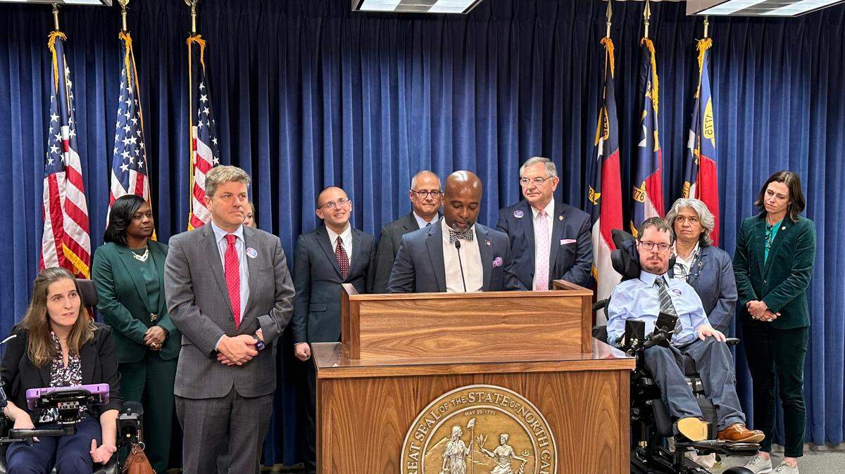Democratic Rep. Zack Hawkins speaks during a press conference about the need to increase funding for the Innovations Waiver program on Wednesday, March 26, 2025 at the Legislative Building in Raleigh, N.C. Behind him are Ray and Nicholas Hemachandra. To the right is Jon D’Angelo, chairman of the N.C. Council on Developmental Disabilities.