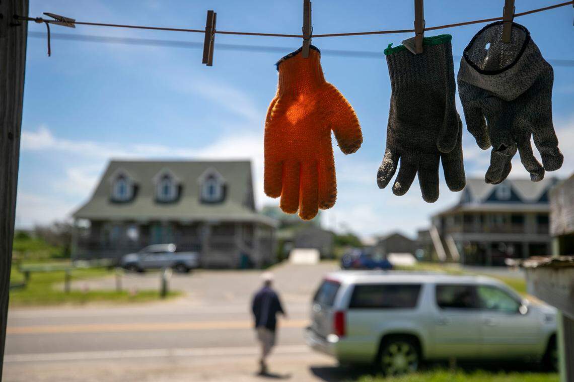 Work gloves, used to clean fish, dry in the morning sun at Jeffrey’s Seafood along NC 12 on Thursday, July 1, 2021 in Hatteras, N.C.