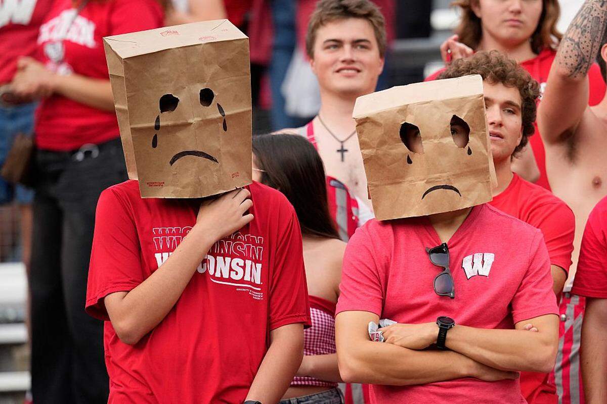 Wisconsin Badgers fans wear garbage bags over their faces during the game against the Ohio State Buckeyes at Camp Randall Stadium on October 18, 2025 in Madison, Wisconsin.