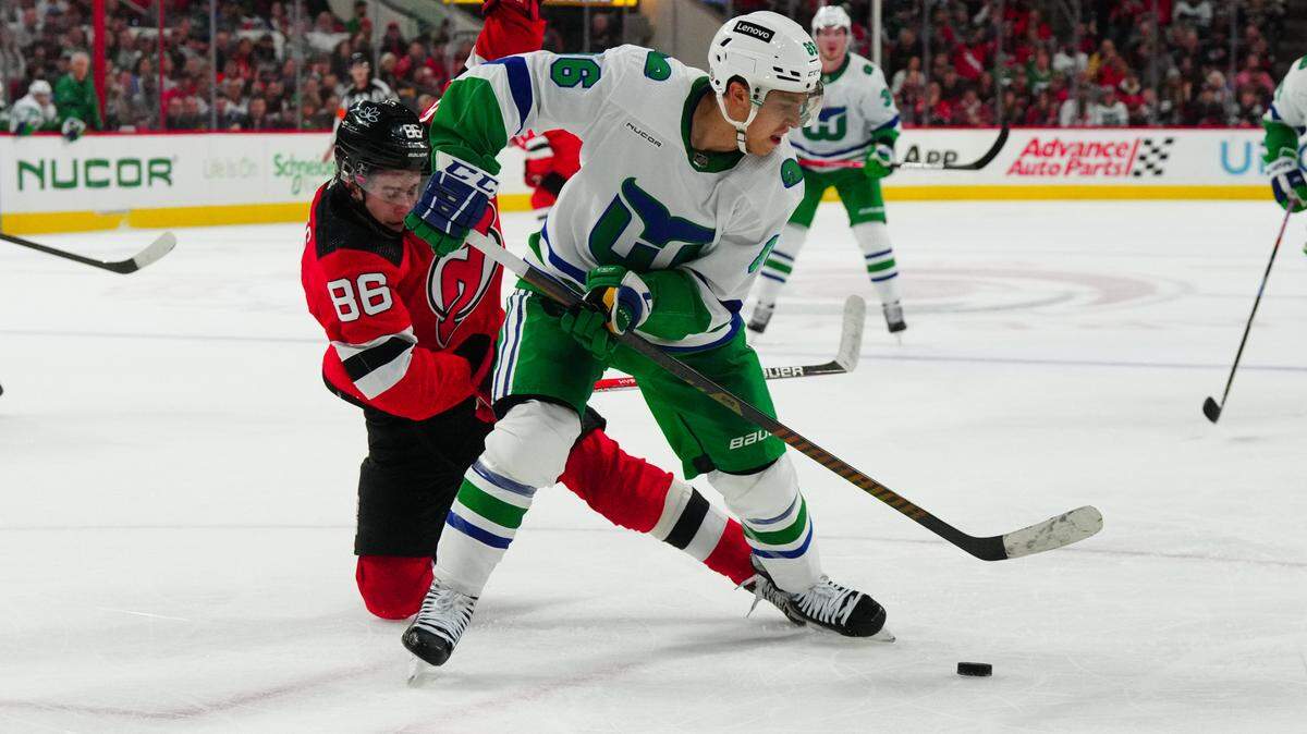 Carolina Hurricanes left wing Teuvo Teravainen (86) and New Jersey Devils center Jack Hughes (86) battle over the puck during the second period at PNC Arena.