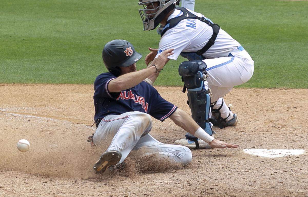 Auburn’s Edouard Julien (10) slides into home on North Carolina catcher Brandon Martorano (4) in the eight inning to score and give Auburn a 7-5 lead on a double by Rankin Woley during the NCAA Super Regional on Saturday, June 8, 2019 at Boshamer Stadium in Chapel Hill, N.C.