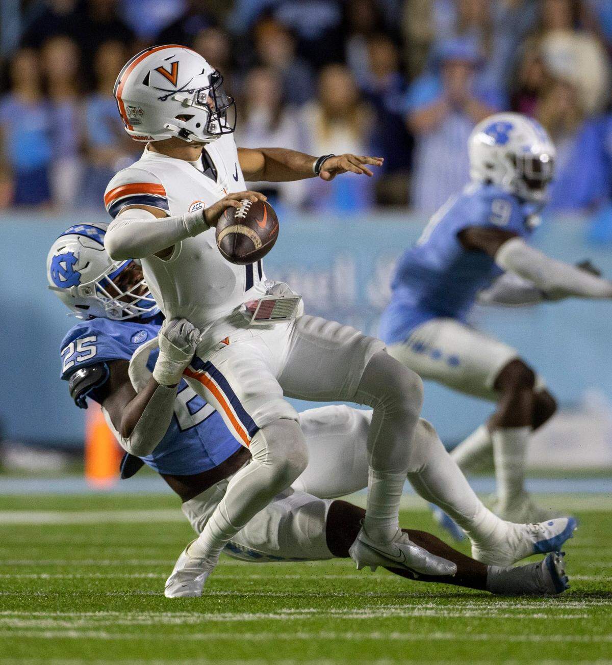 Virginia quarterback Tony Musket (11) is stopped by North Carolina’s Kaimon Rucker (25) in the first quarter on Saturday, October 21, 2023 at Kenan Stadium in Chapel Hill, N.C. Musket was called for intentional grounding.