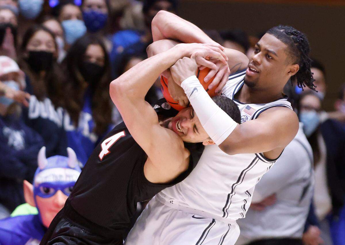 Duke’s Trevor Keels (1) and N.C. State’s Jericole Hellems (4) fight for the ball during the second half of Duke’s 88-73 victory over N.C. State at Cameron Indoor Stadium in Durham, N.C., Saturday, January 15, 2022.