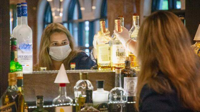Annabel Butler, restaurant manager and sommelier at Il Palio, restocks liquor at the restaurant’s bar ahead of opening the following evening with 9 reservations under Gov. Roy Cooper’s Phase Two of reopening during the coronavirus pandemic, on Thursday, May 21, 2020, in Chapel Hill, N.C.