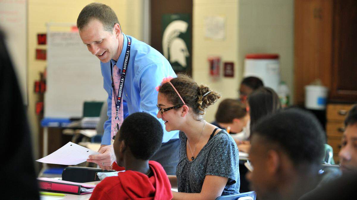 Justin Parmenter, a language arts teacher at Waddell Language Academy in Charlotte, N.C., works with students in his classroom.