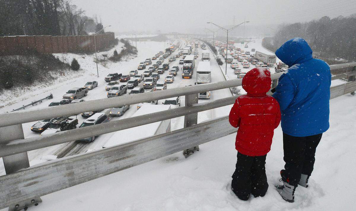 Pedestrians stop to look at the mess I-85 had become as motorists and pedestrians attempt to get home as the Triangle is pounded by a winter storm Wednesday Feb. 12, 2014 in Durham, NC.