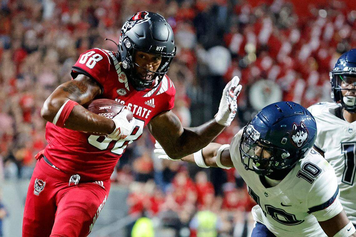North Carolina State’s Devin Carter (88) prepares to stiff-arm Connecticut’s Chris Shearin (10) following a reception during the first half of an NCAA college football game in Raleigh, N.C., Saturday, Sept. 24, 2022.