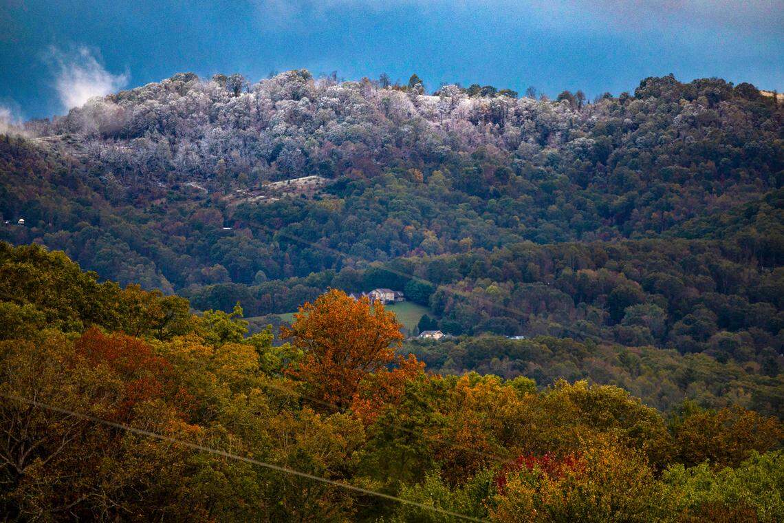 The top of the mountain ridge above Clyde, N.C. is covered with a dusting of snow, as trees lower in the valley show their fall colors on Wednesday, October 16, 2024 in Clyde, N.C.