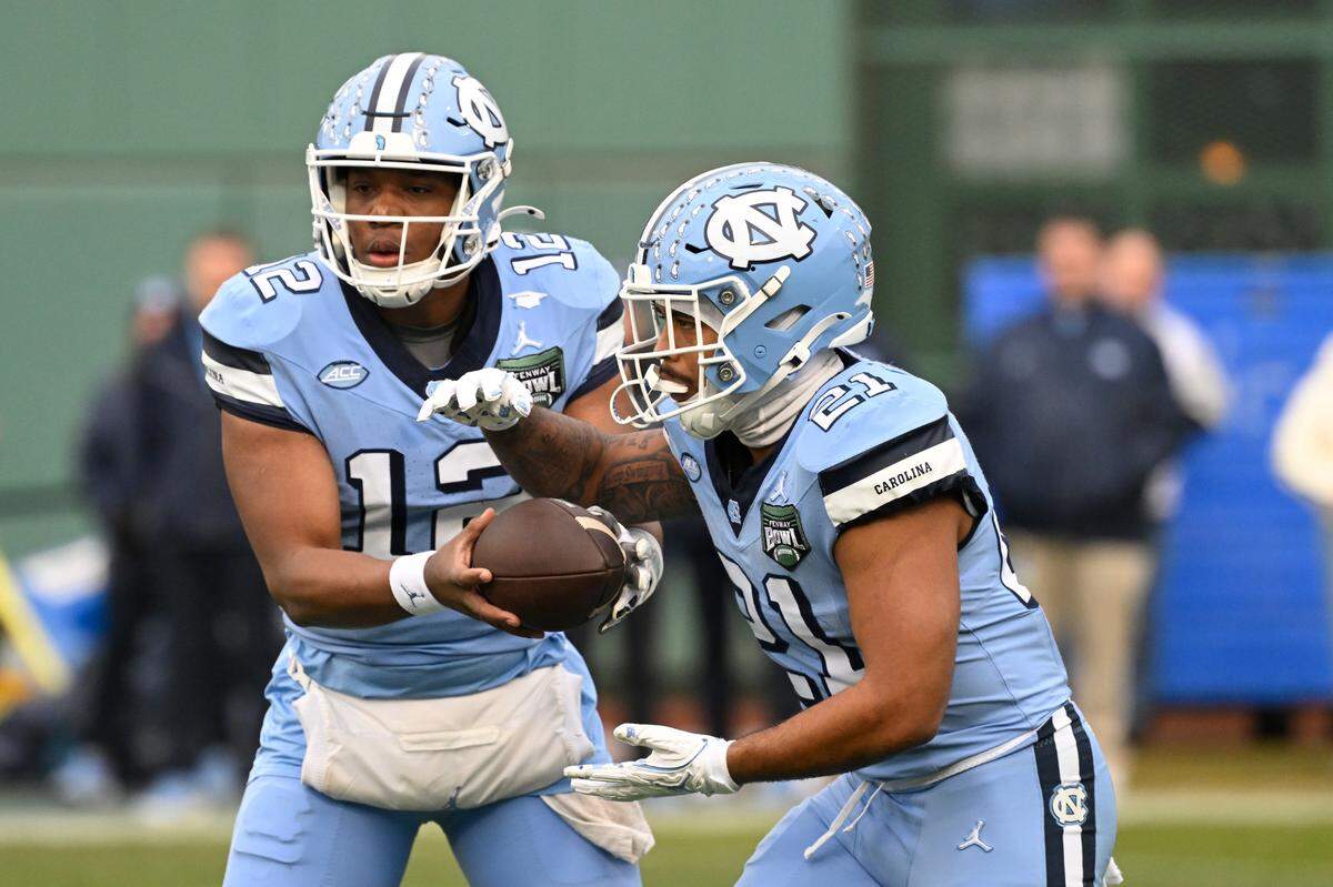 North Carolina Tar Heels quarterback Jacolby Criswell (12) hands the ball to running back Davion Gause (21) during the first half against the Connecticut Huskies at Fenway Park. 