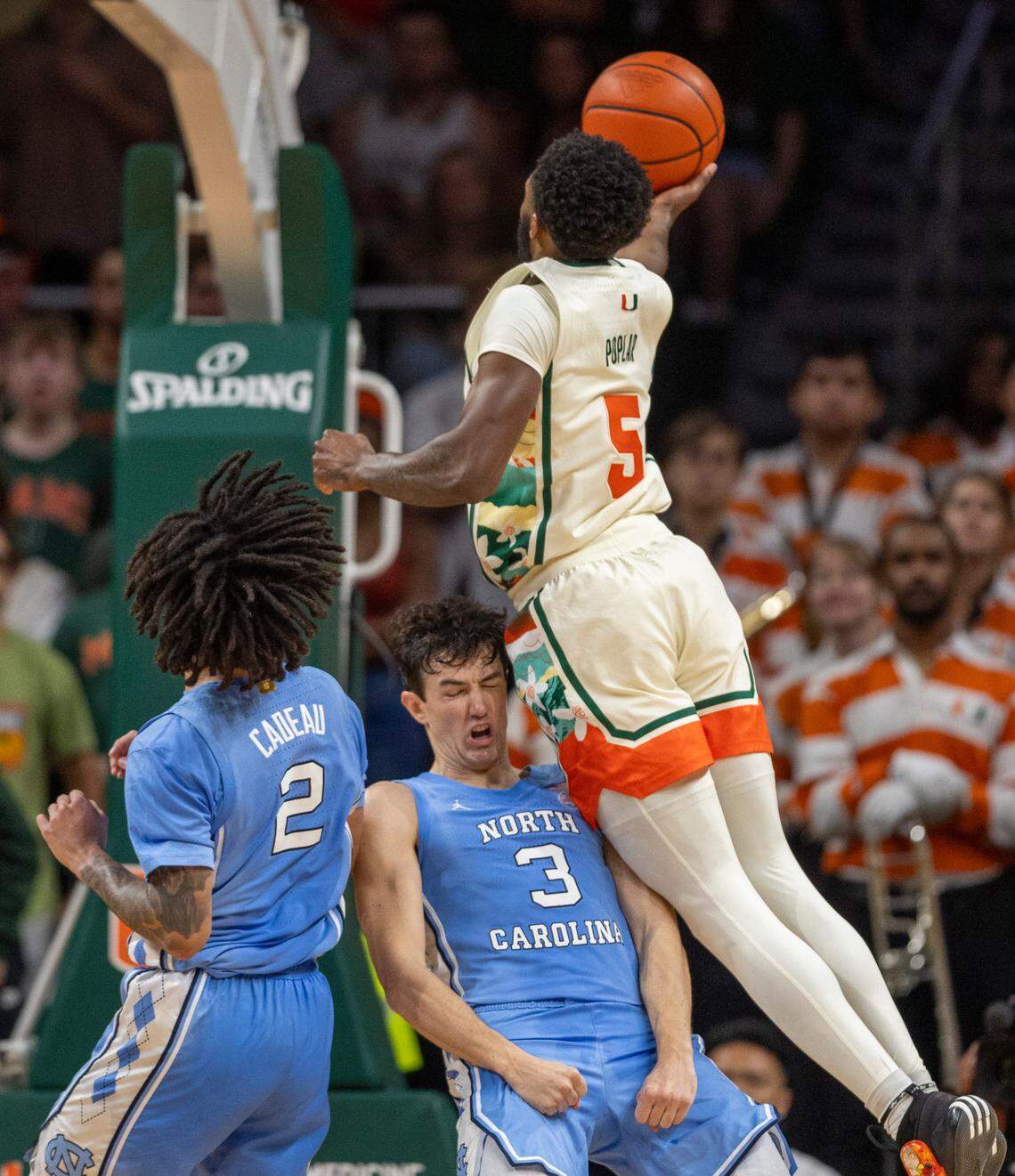 North Carolina’s Cormac Ryan (3) takes a charge from Miami’s Wooga Poplar (5) in the first half on Saturday, February 10, 2024 at the Watsco Center in Coral Gables, Florida.