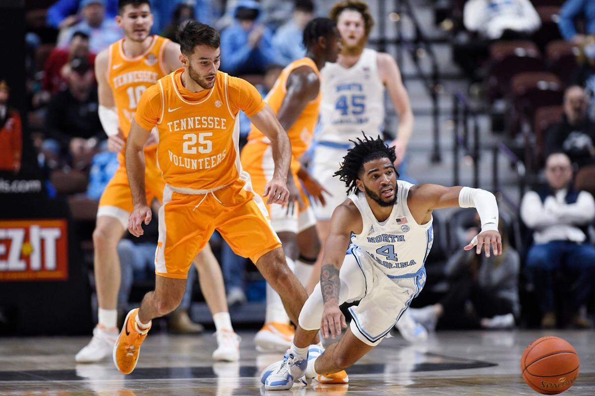 North Carolina’s R.J. Davis (4) falls to the floor as Tennessee’s Santiago Vescovi (25) defends in the first half of an NCAA college basketball game, Sunday, Nov. 21, 2021, in Uncasville, Conn. (AP Photo/Jessica Hill)