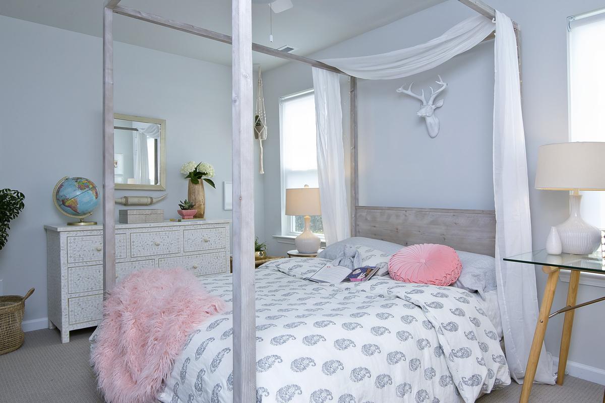 The accessories shown in this bedroom were collected to give the space an authentic feel; featuring a bone inlay dresser, modern canopy bed and glass top desk.