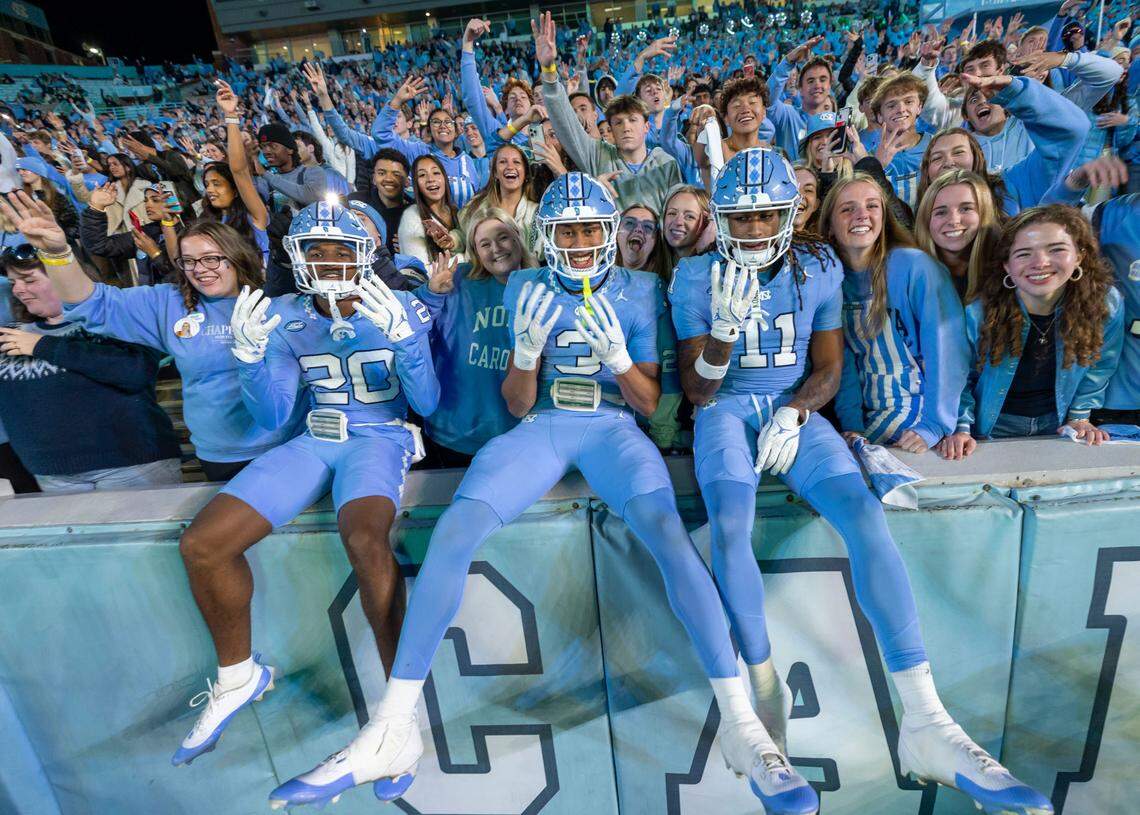 North Carolina defensive backs Jason Thompson (20), Malcolm Ziglar (3) and Ty Adams (11) jump into the student section at the start of the fourth quarter of play against Wake Forest on Saturday, November 16, 2024 at Kenan Stadium in Chapel Hill, N.C.