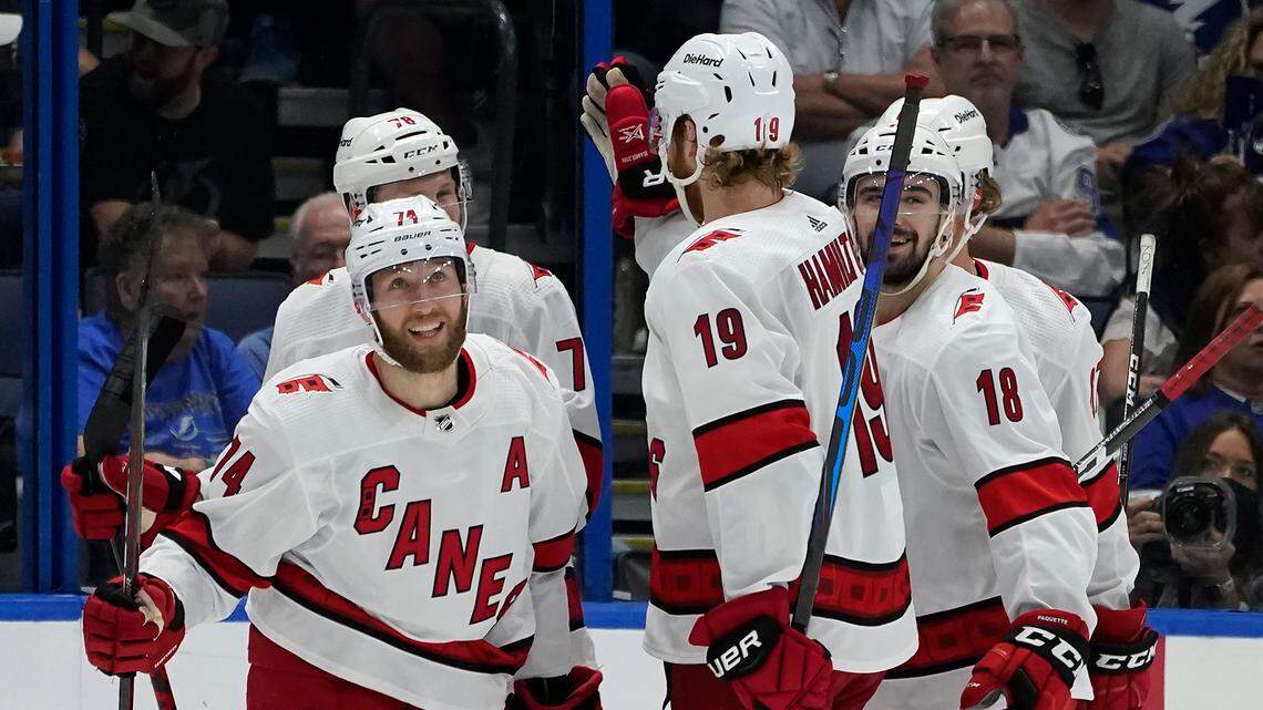 Carolina Hurricanes defenseman Jaccob Slavin (74) celebrates with teammates, including defenseman Dougie Hamilton (19) and center Cedric Paquette (18) after scoring against the Tampa Bay Lightning during the second period in Game 4 of an NHL hockey Stanley Cup second-round playoff series Saturday, June 5, 2021, in Tampa, Fla. (AP Photo/Chris O’Meara)