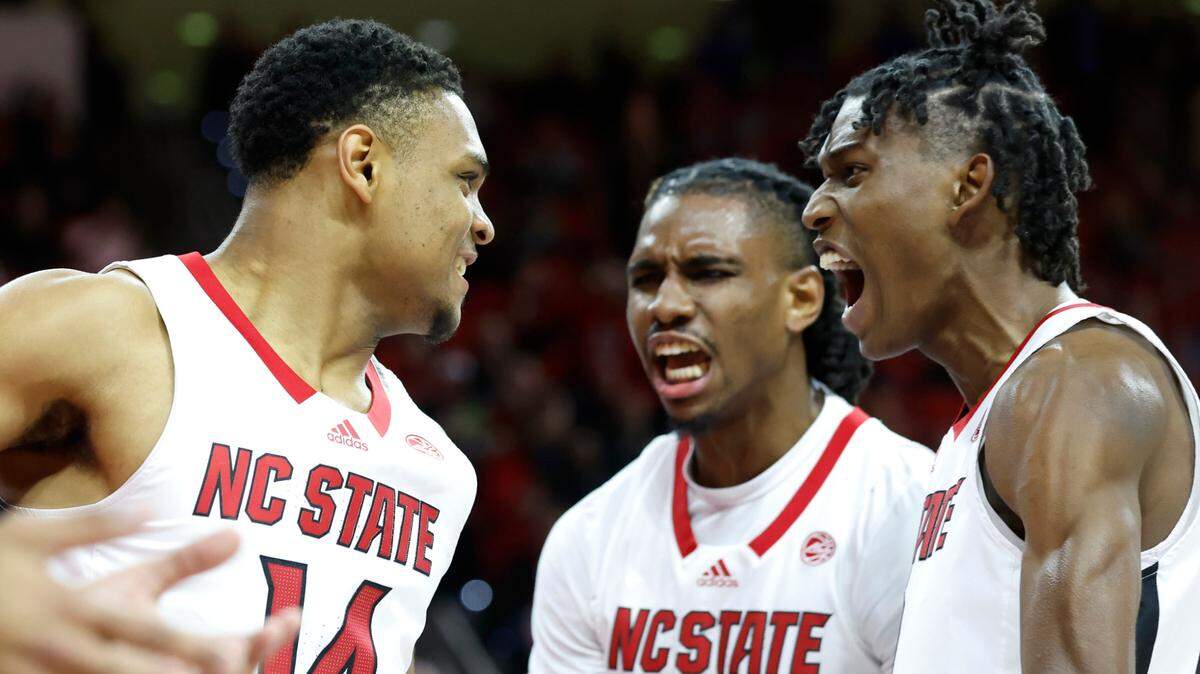 N.C. State’s Terquavion Smith (0) and Greg Gantt (23) celebrate with Casey Morsell (14) after Morsell made the basket while being fouled during the first half of N.C. State’s game against FSU at PNC Arena in Raleigh, N.C., Wednesday, Feb. 1, 2023.