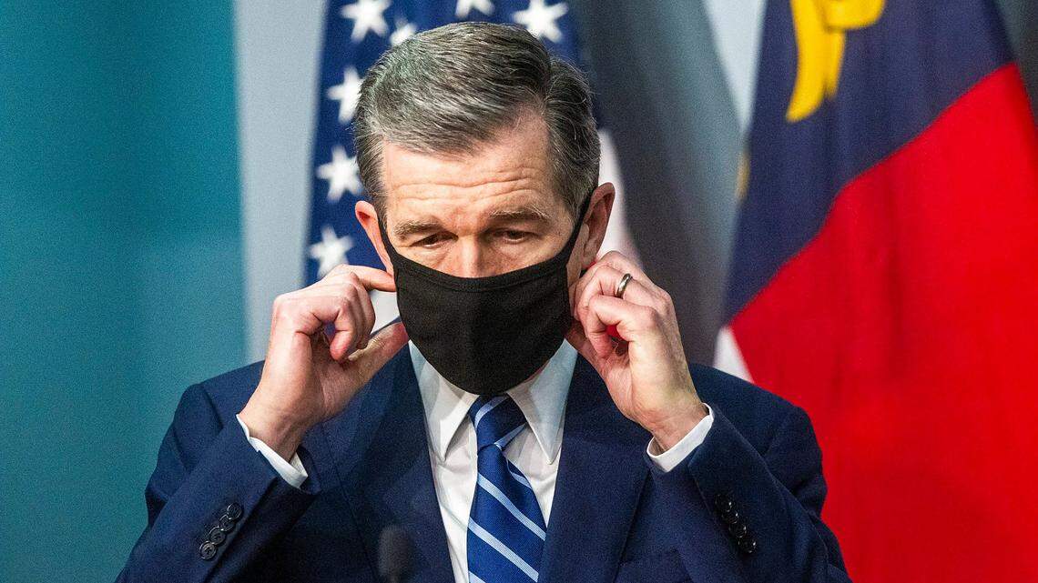 Gov. Roy Cooper removes his mask before speaking during a briefing on North Carolinaís coronavirus pandemic response Tuesday, Dec. 8, 2020 at the NC Emergency Operations Center in Raleigh.