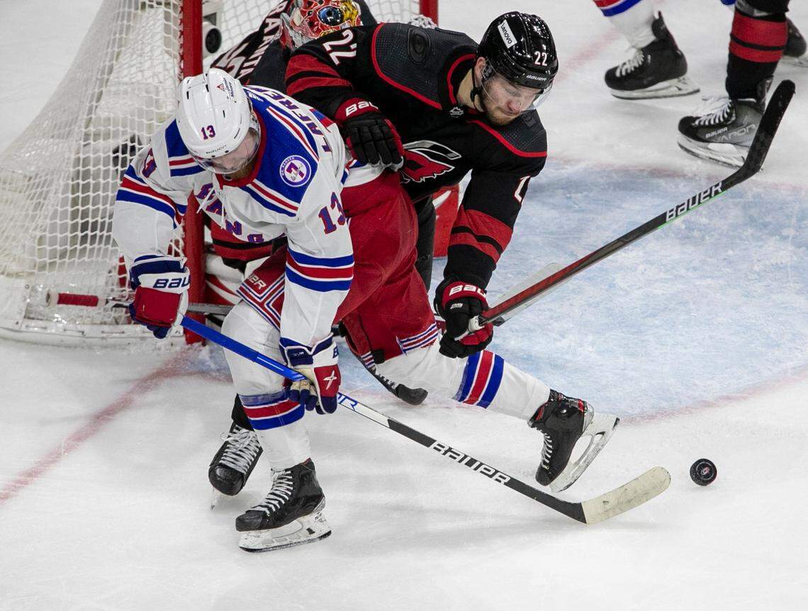 Carolina Hurricanes Brett Pesce (22) defends New York Rangers Alexis Lafreniere (13) in front of the Hurricanes goalie Antii Raanta (32) in the second period on Friday, May 20, 2022 during game two of the Stanley Cup second round at PNC Arena in Raleigh, N.C.
