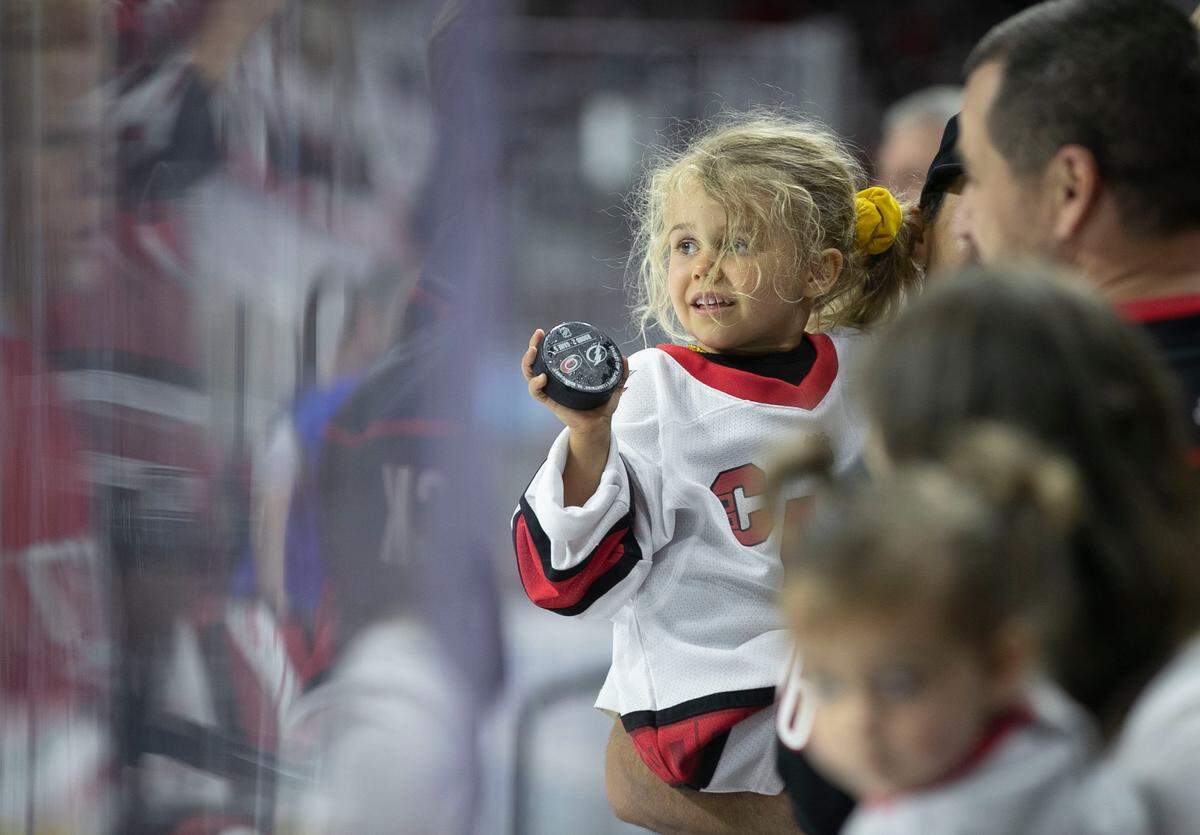 Four-year-old Frances Steffens covets a hockey puck tossed her way during the Carolina Hurricanes’ pre-game warm up prior to game five of their Stanley Cup series against Tampa Bay on Tuesday, June 8, 2021 at PNC Arena in Raleigh, N.C.