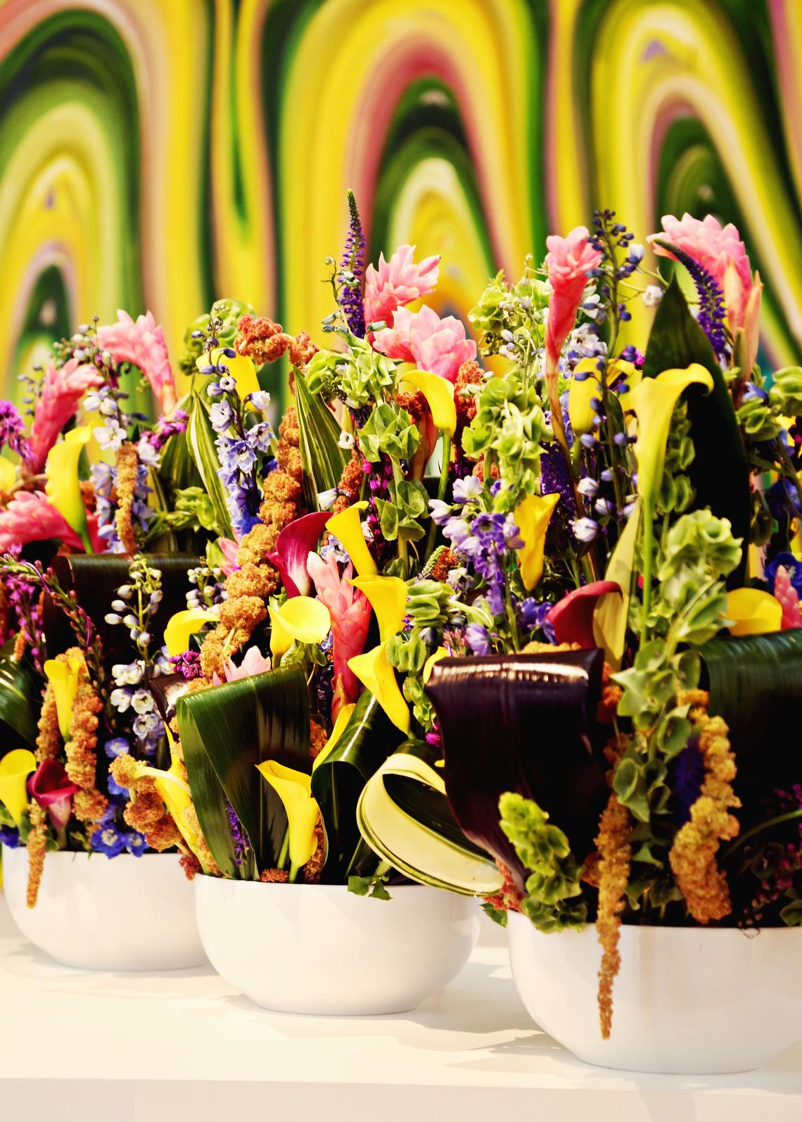 Scot Buck's finished floral piece evokes the same tone as the painting in the background, "Interior Ghosts No. 7" by Karen Davie, at North Carolina Museum of Art in Raleigh's fourth annual Art in Bloom event.