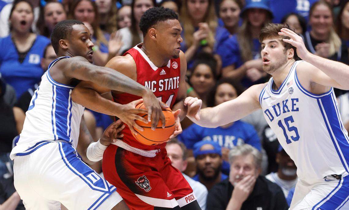 N.C. State’s Casey Morsell (14) drives between Duke’s Dariq Whitehead (0) and Ryan Young (15) during the first half of N.C. State’s game against Duke at Cameron Indoor Stadium in Durham, N.C., Tuesday, Feb. 28, 2023.