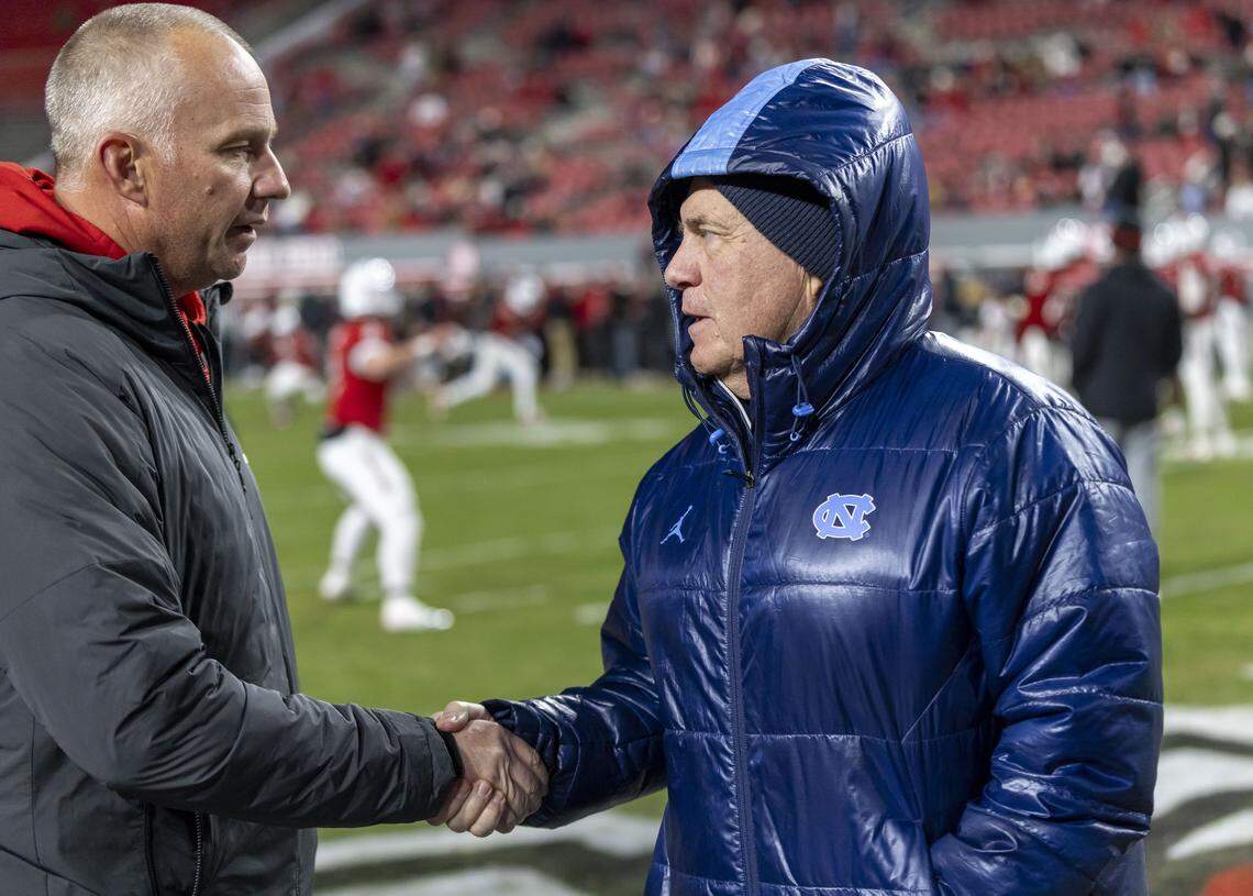 North Carolina coach Bill Belichick shakes hands with N.C. State coach Dave Doeren prior to their game on Saturday, November 29, 2025 at Carter-Finley Stadium in Raleigh, N.C.