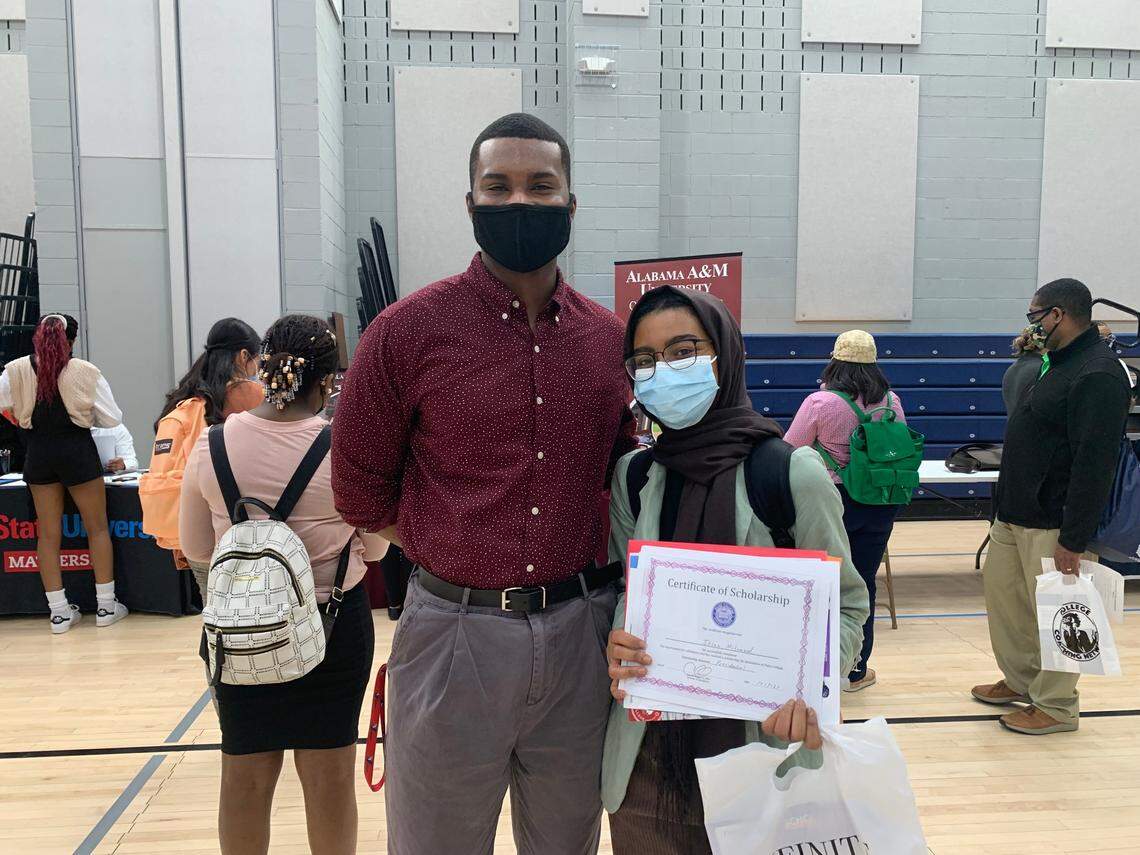 College Advising Corps advisor Bryant Lewis (left) congratulates his student Ihsan Mohammed (right) for earning a college scholarship.