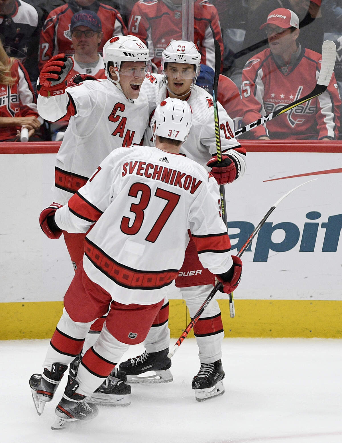 Carolina Hurricanes defenseman Jake Gardiner (51) celebrates his game-winning goal with center Sebastian Aho (20), of Finland, and right wing Andrei Svechnikov (37), of Russia, in overtime of an NHL hockey game against the Washington Capitals, Saturday, Oct. 5, 2019, in Washington. The Hurricanes won 3-2.
